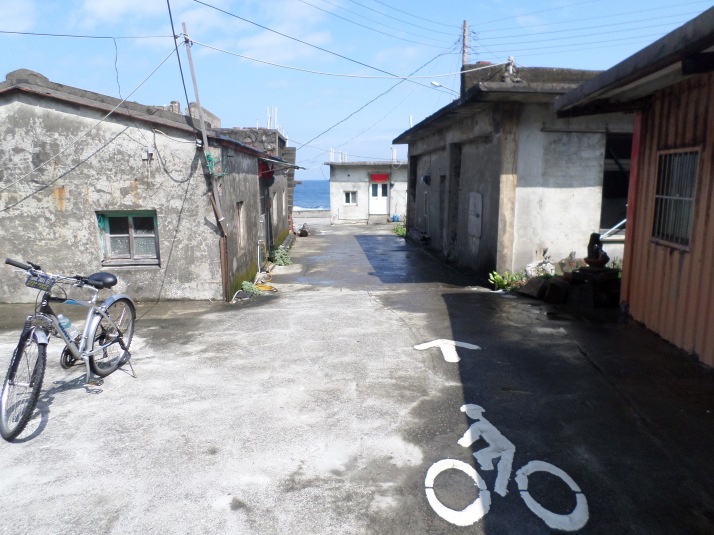 bike trail cutting through a small, run-down fishing village
